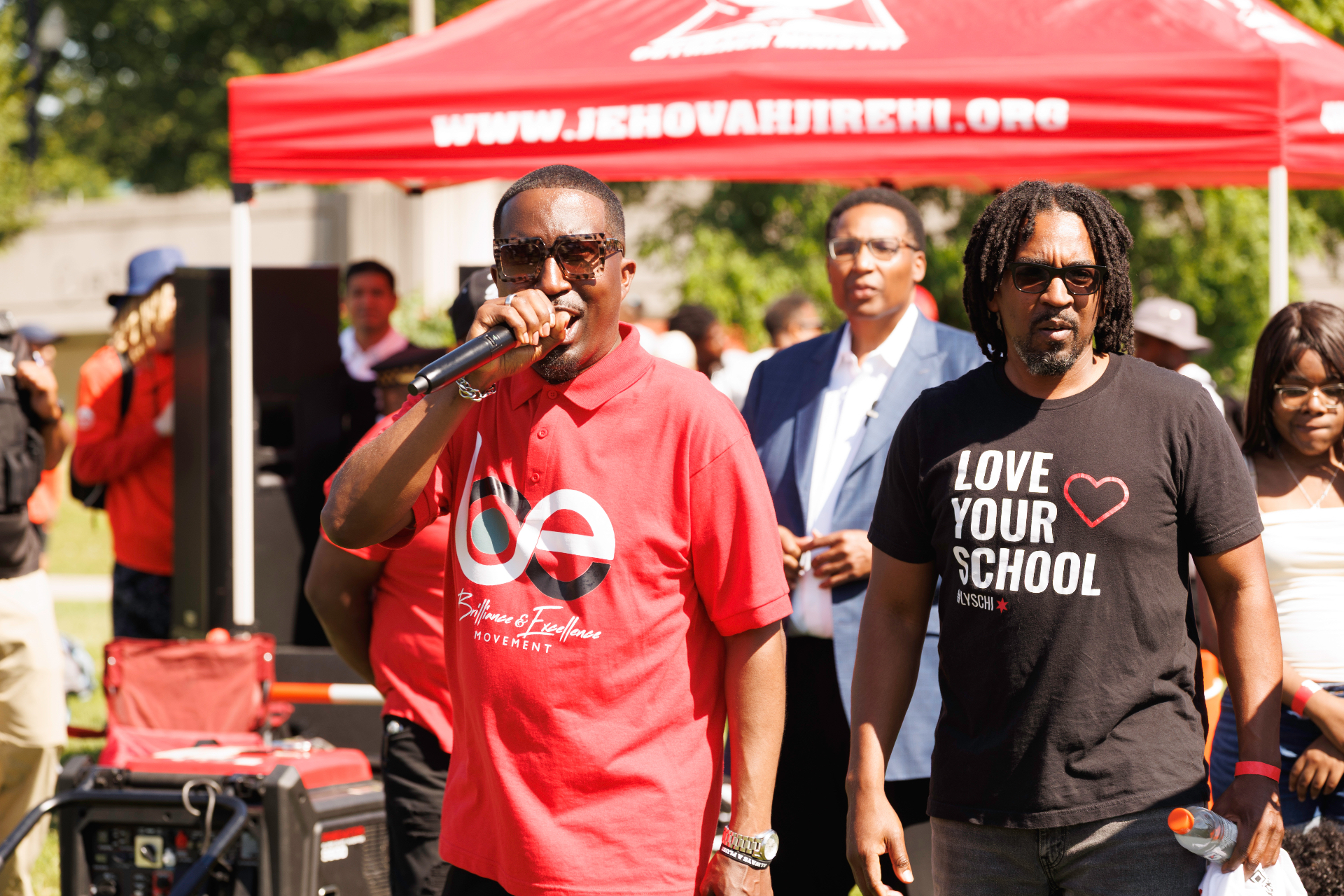 A community leader speaks under the red tent